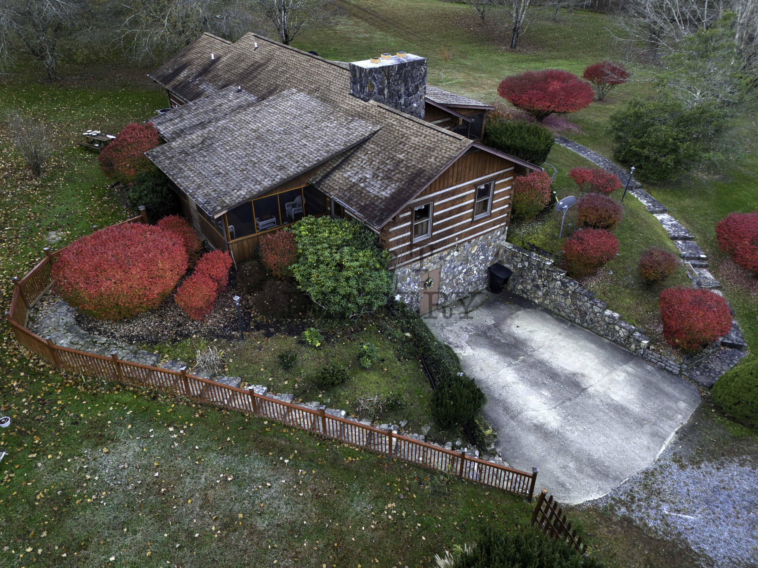 Arial photo of a log home showing the walkways, landscaping, and condition.